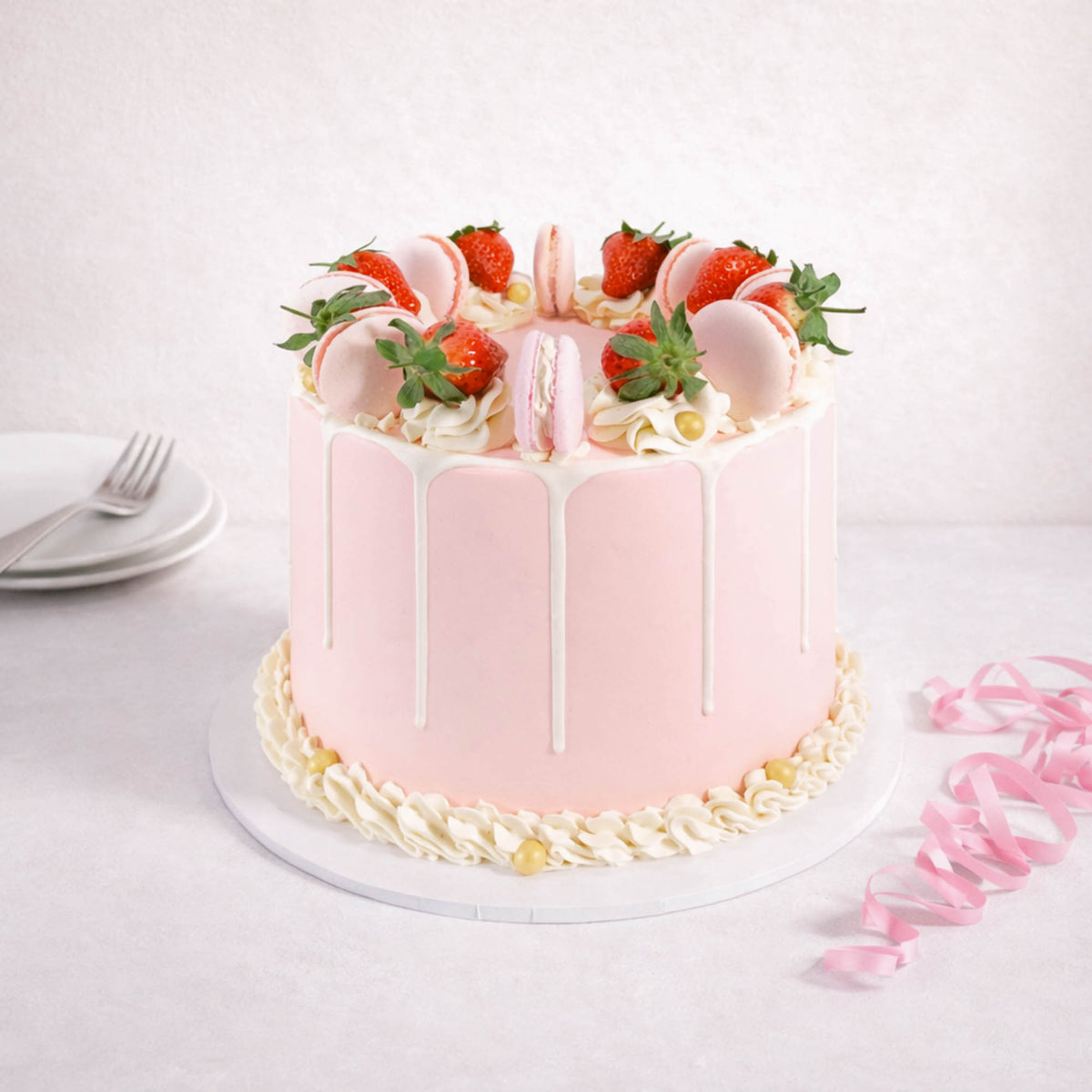 Gluten friendly Free From Strawberry Macaroon Cake with pink buttercream, white drip, strawberries and macarons