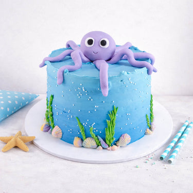 Under The Sea Cake with blue buttercream, seaweed, shells and a smiling purple octopus