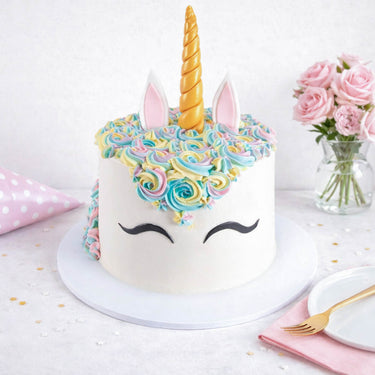 Free From Unicorn Cake with a gold horn, rainbow buttercream mane and fondant ears, with roses and confetti