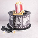 Movie Cake designed as a film reel, with a popcorn box, 3D glasses and fondant film strip
