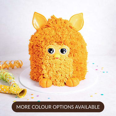 Gluten friendly Free From Furby Cake with orange buttercream fur, big eyes and fondant ears, with confetti