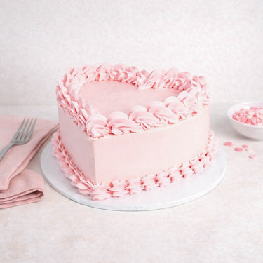 Mini Heart Cake with pale pink buttercream, piped rosettes and ruffles, with pink confetti