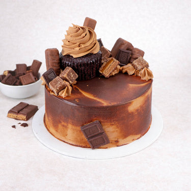 Mini Chocolate Overload Cake topped with a chocolate cupcake, broken chocolate bars and sweets
