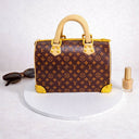 Handbag Cake made to look like a designer monogram handbag, next to sunglasses and nail varnish