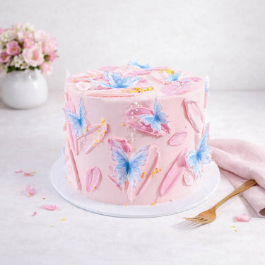 Butterfly Cake with pale pink buttercream, blue edible butterflies and sugar pearls