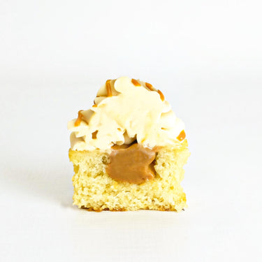 Salted Caramel Cupcake cut in half, showing the caramel filling, topped with caramel buttercream and a stroopwafel
