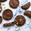 Triple Chocolate Cookies with white and milk chocolate chunks, whole and broken, on marble
