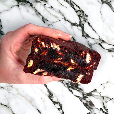 Hand holding a Red Velvet Cookie from the Mixed Cookie Box