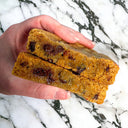 Hand holding a cookie broken in half, showing melted chocolate chips