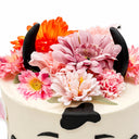 Cow Cake with white buttercream, pink silk flowers, black horns and fondant cow spots