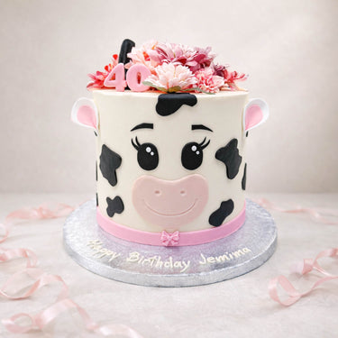 Cow print 40th birthday cake with pink flowers on top