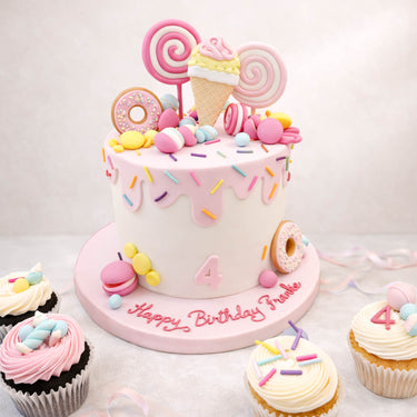 Sweetie themed birthday cake with lollipops, doughnuts and cupcakes