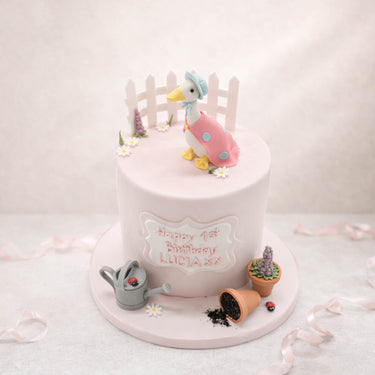 Garden themed birthday cake with a duck, a fence and plant pots