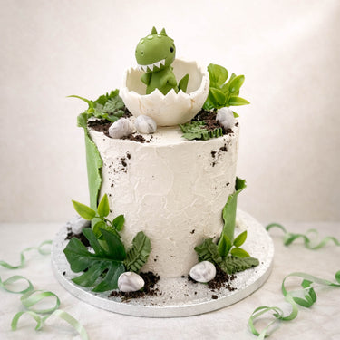 Dinosaur cake with a baby dinosaur hatching from an egg