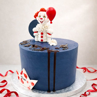 Scary clown cake with a red balloon and a paper boat