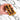Hand holding split Sticky Toffee Cookie, revealing gooey date and toffee filling, highlighting its chewy texture and handmade quality from Harry Batten's bakery.