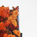 Floral Cutout Wedding Cake with orange sugar flowers cascading down black tiers