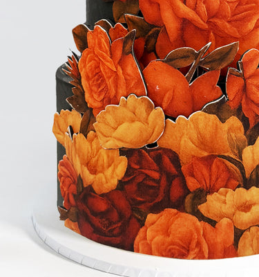 Dark Floral Cutout Wedding Cake with bright sugar flowers on a white board