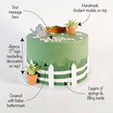 Gardening Cake with labels showing the green buttercream, fondant watering can, succulents, fence and message space