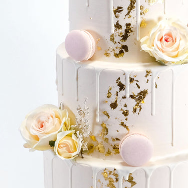 Gold Leaf Wedding Cake with smooth buttercream, white drip, gold leaf, pink macarons and blush roses
