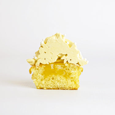 Lemon Cupcake cut in half, showing vanilla sponge with a lemon coulis centre and lemon buttercream
