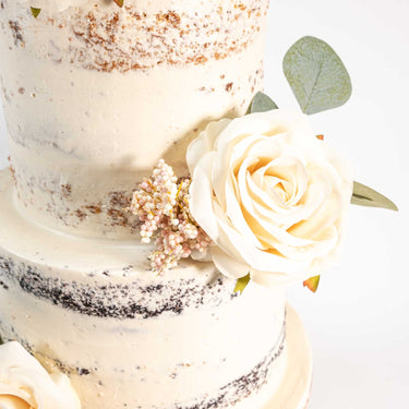 Naked Wedding Cake with an ivory rose, pale pink berries and eucalyptus