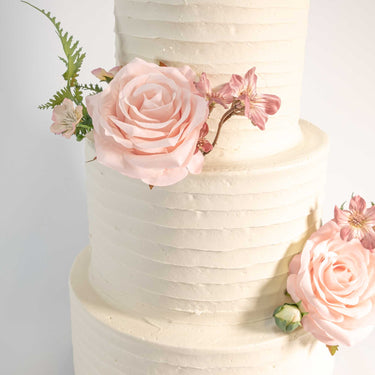 Three tier Rustic Wedding Cake with textured buttercream, blush pink roses and greenery