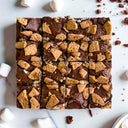 16 S'mores Brownies topped with crushed biscuits, with mini marshmallows