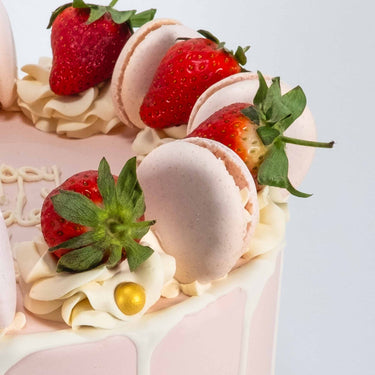 Gluten friendly Free From Strawberry Macaroon Cake with rosettes, fresh strawberries, macarons and gold pearls