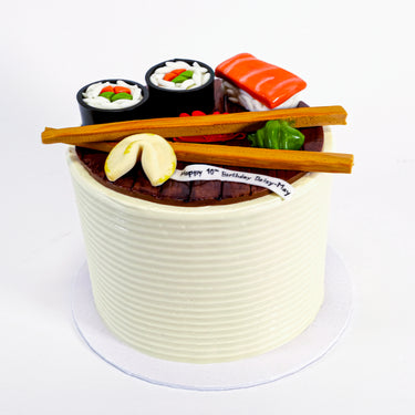 Sushi Cake with fondant sushi, chopsticks and a 10th birthday banner on smooth buttercream