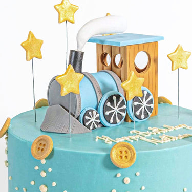 Train Cake with a fondant steam train on top, gold stars, piped pearls and sugar buttons