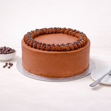 Chocolate Cake with piped buttercream and chocolate chips on a silver board