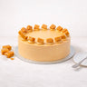 Salted Caramel Cake with smooth buttercream and caramel pieces on a silver board