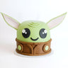 Free From Star Wars Cake shaped as Grogu, with a green fondant head, big eyes and a brown robe