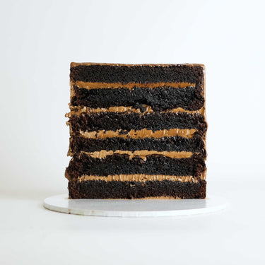Slice of Chocolate Overload Cake showing six layers of chocolate sponge and chocolate buttercream
