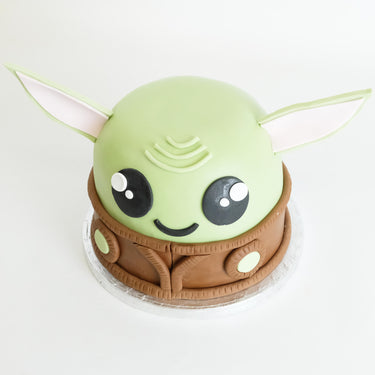 Star Wars Grogu Cake in green and brown fondant with big eyes and a robe collar